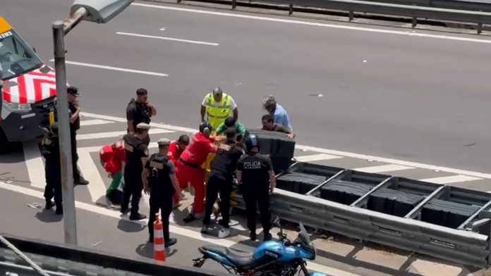 Un motociclista chocó contra un auto en la Autopista 25 de Mayo y quedó atrapado bajo un guardarraíl